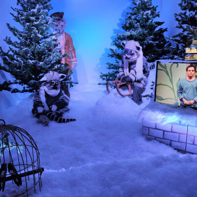 Bild vergrößern: Eingebettet in eine zauberhafte Schneelandschaft ist ein Bildschirm, auf dem Trailer der bisher produzierten Theaterstücke der Saison 2020/21 zu sehen sind.