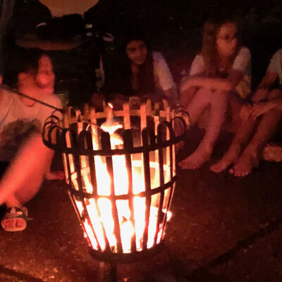 Bild vergrößern: Auf dem Bild sind die Mädchen beim Lagerfeuer zu sehen.